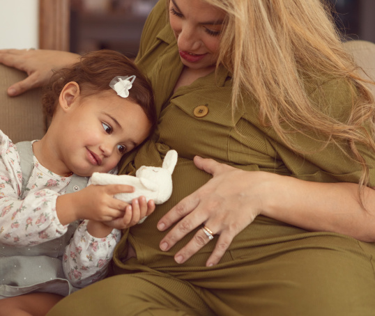 Toddler and pregnant mum sitting on a sofa